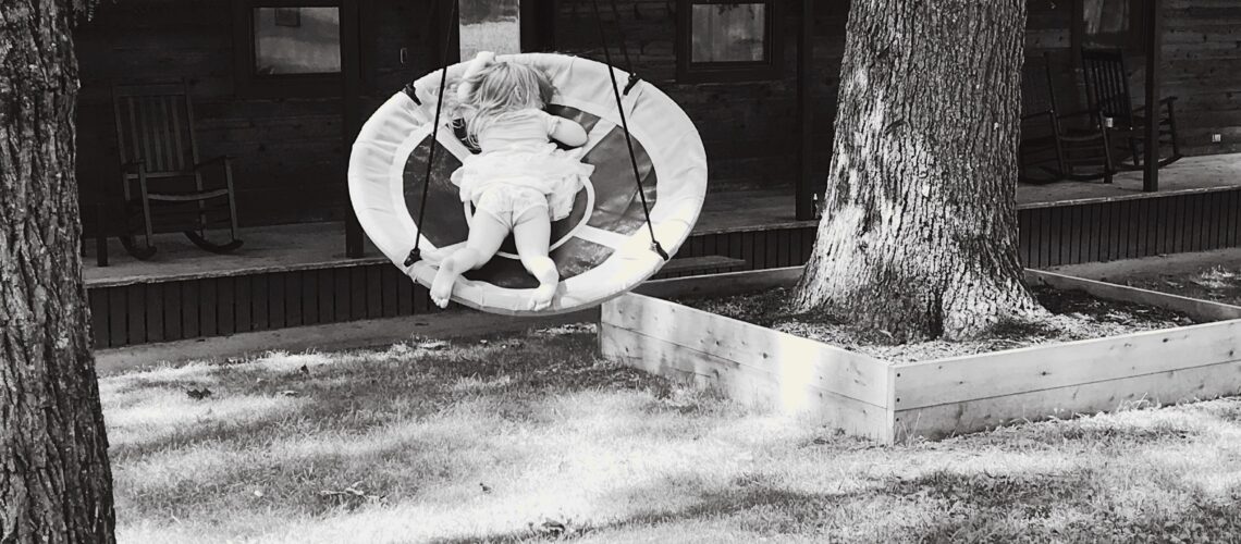 Image of little girl swinging in a tree swing
